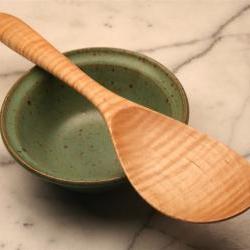 Hand carved wooden spoon rice spoon for serving sticky rice out of a rice cooker.